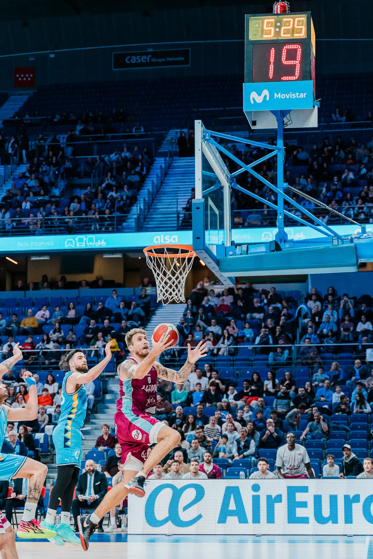 Jugadora de baloncesto atacando la canasta